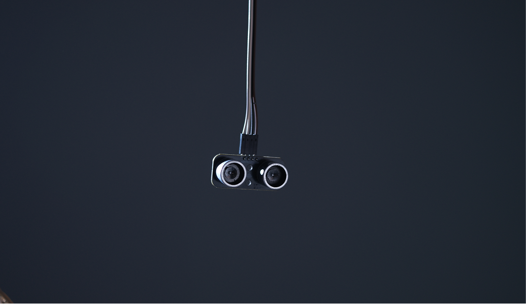 HC-SR04 distance sensor suspended above the interaction area